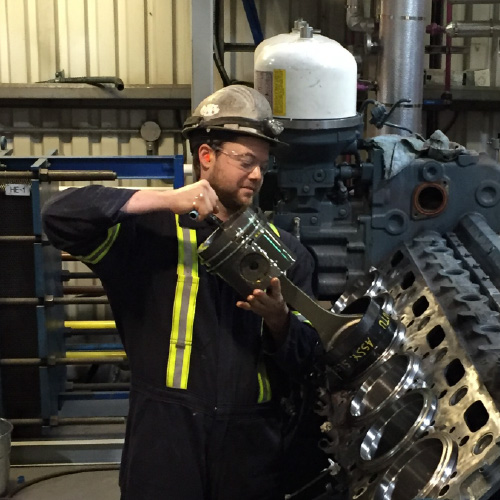 Chad Leroux checking the piston in a Diesel Engiine at the remote location.